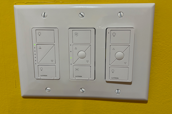 Smart dimmer switches against a yellow wall