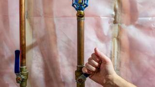 Technician closing main water valve for leak protection