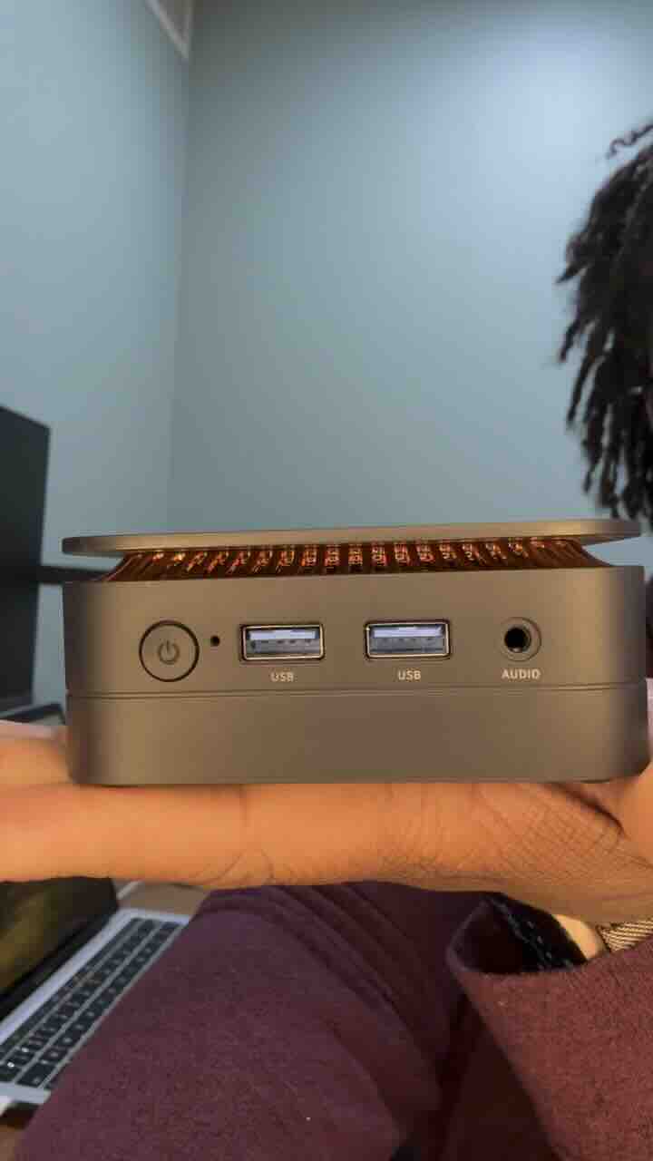 Image of person holding a mini PC on the palm of their hand