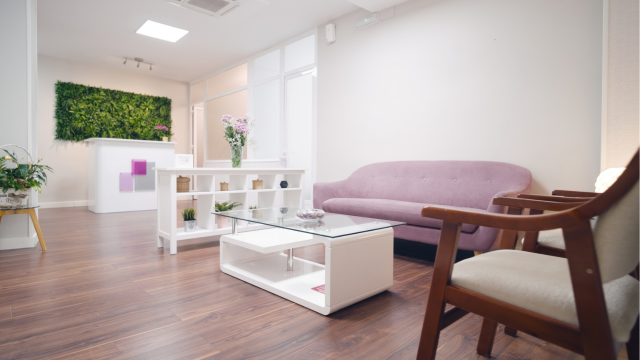 Professional waiting area with fuchsia sofa and reception desk
